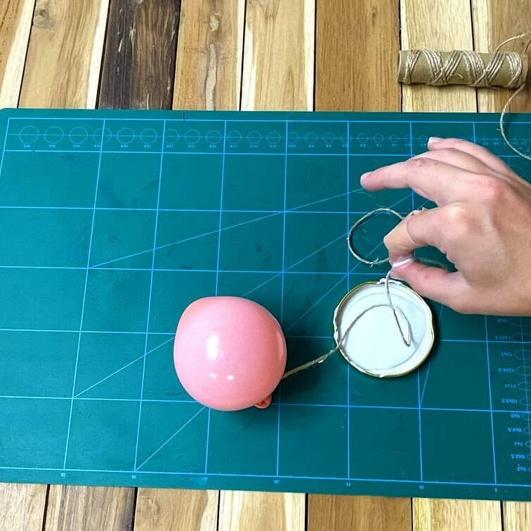 Imbibez la cordelette de colle pour créer une boule en ficelle avec des ballons de baudruche.